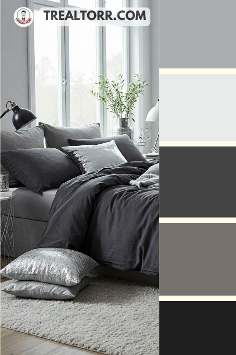 A bedroom with charcoal gray bedding, silver throw pillows, and a soft white rug, creating an elegant winter-inspired space
