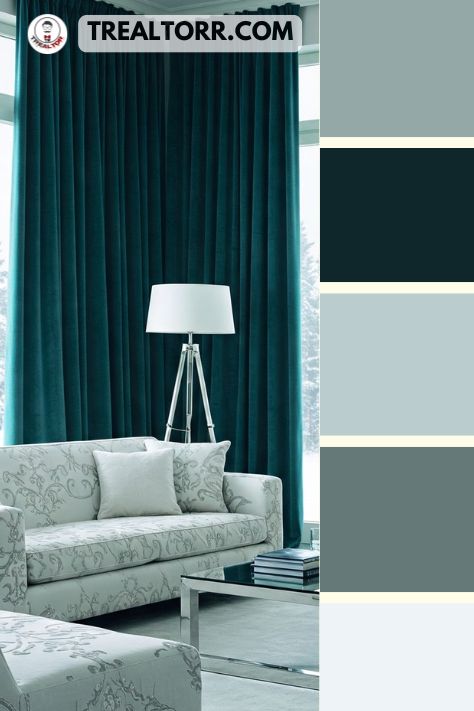 A living room with deep teal curtains, snow-white sofas, and metallic silver accents, evoking a cool and luxurious winter vibe